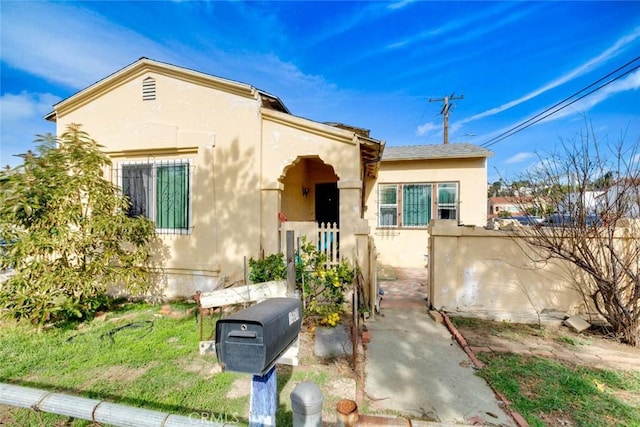 view of front of house featuring fence and stucco siding