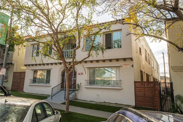 view of front facade featuring fence and stucco siding