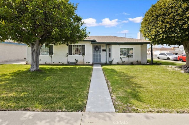 ranch-style house with stucco siding, a chimney, and a front yard