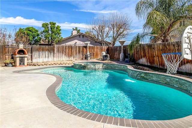 view of swimming pool featuring a patio, a fenced backyard, and a pool with connected hot tub