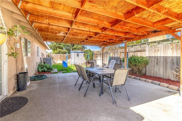 view of patio / terrace featuring an outbuilding, outdoor dining area, a fenced backyard, central air condition unit, and a shed