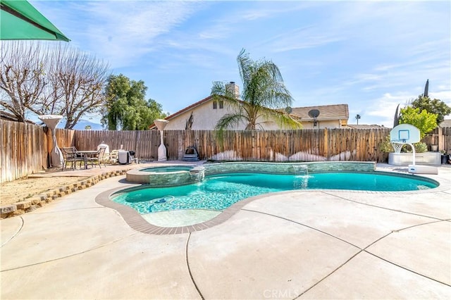 view of swimming pool with a pool with connected hot tub, a patio area, and a fenced backyard