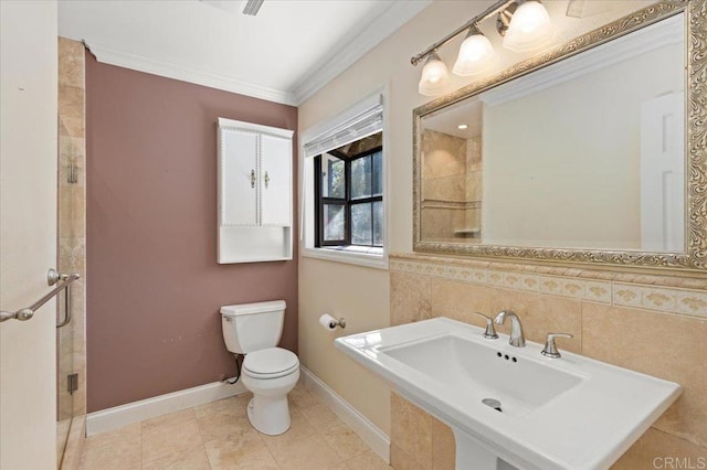 full bathroom featuring toilet, a sink, baseboards, a stall shower, and crown molding