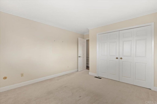 unfurnished bedroom featuring light carpet, crown molding, and baseboards