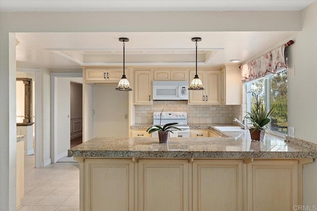 kitchen featuring cream cabinets, a peninsula, white appliances, decorative backsplash, and a raised ceiling