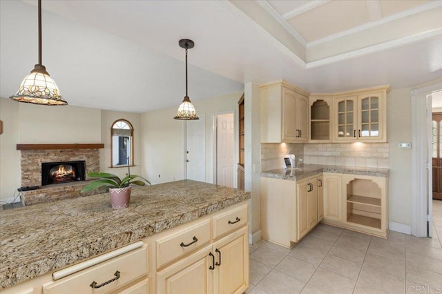 kitchen featuring tasteful backsplash, glass insert cabinets, light countertops, and cream cabinetry