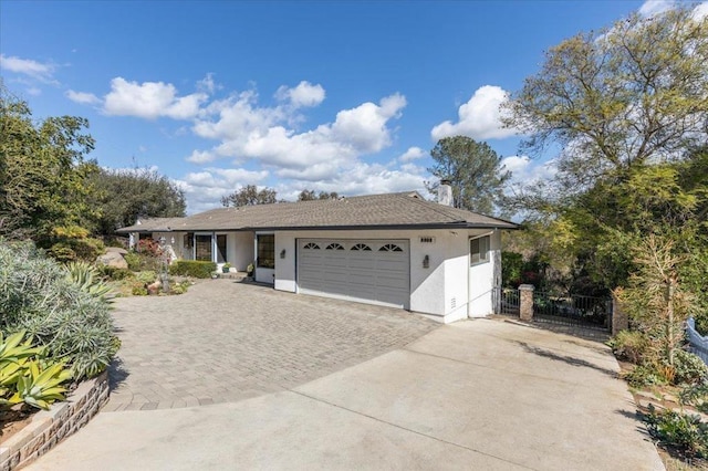 single story home with a garage, fence, decorative driveway, and stucco siding