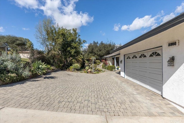 garage with decorative driveway