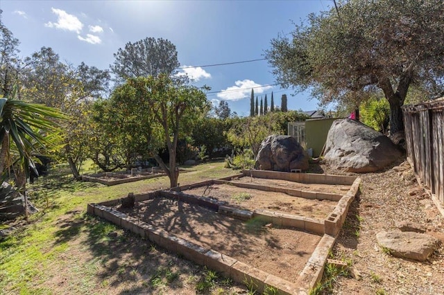 view of yard with a vegetable garden and fence