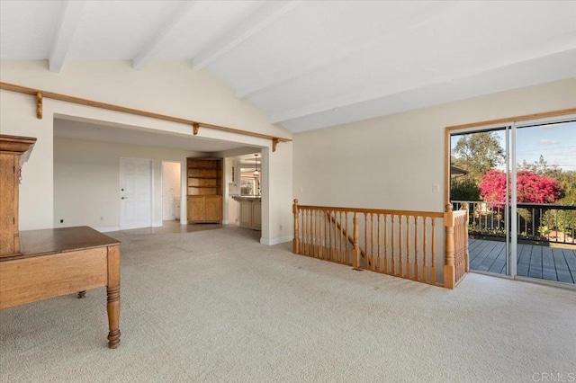 carpeted spare room featuring vaulted ceiling with beams