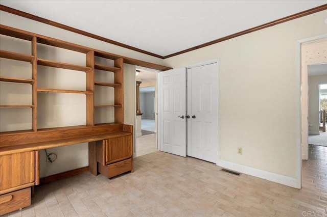 unfurnished office featuring visible vents, baseboards, ornamental molding, light wood-type flooring, and built in desk