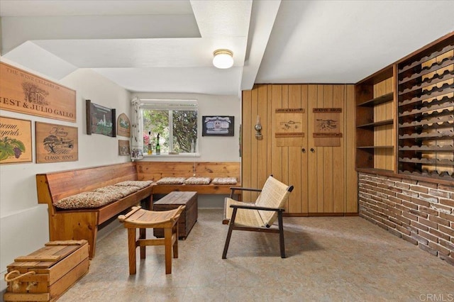 office area featuring built in shelves, brick wall, wooden walls, and wainscoting