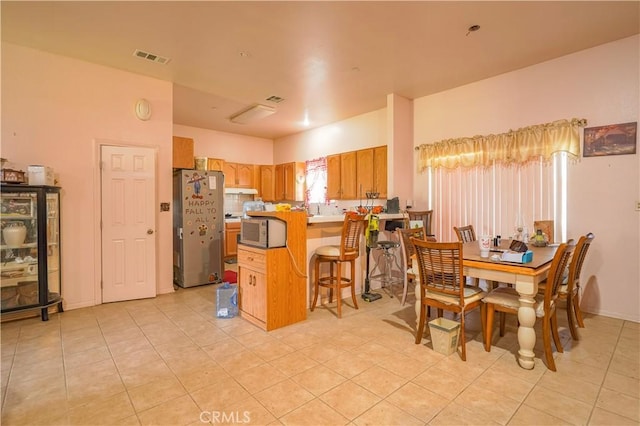 dining area with light tile patterned floors and visible vents