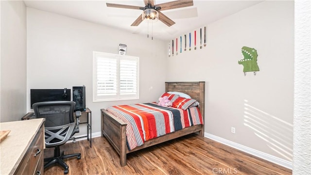 bedroom with ceiling fan, baseboards, and wood finished floors