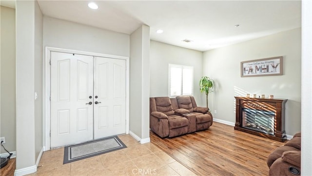 living room with recessed lighting, baseboards, visible vents, a fireplace, and light tile patterned flooring