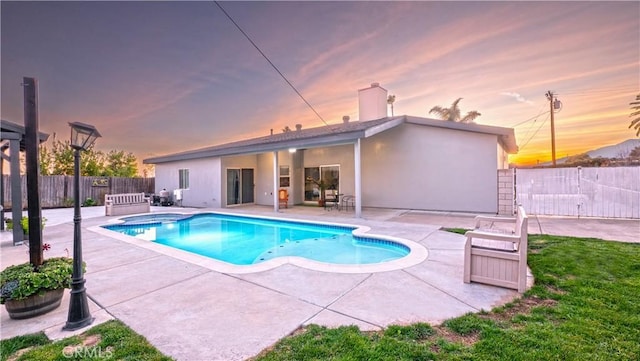 view of swimming pool featuring fence private yard, a patio area, and a pool with connected hot tub