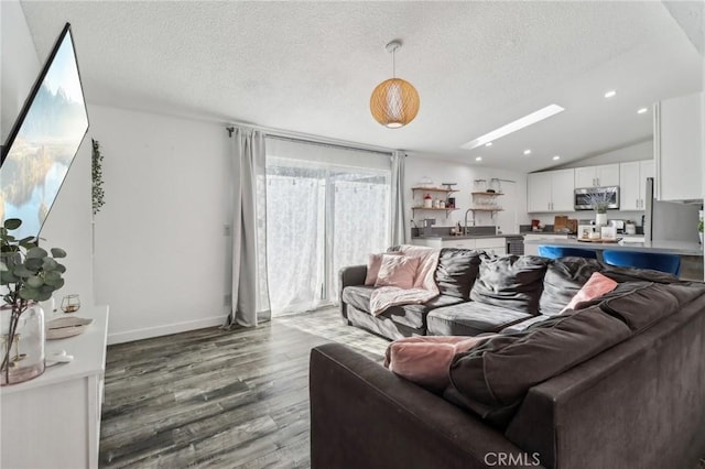 living area with a textured ceiling, vaulted ceiling, wood finished floors, and recessed lighting