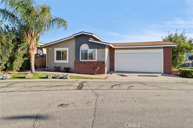 view of front of property with a garage, concrete driveway, and brick siding