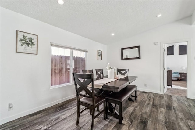 dining room with lofted ceiling, a textured ceiling, wood finished floors, and baseboards