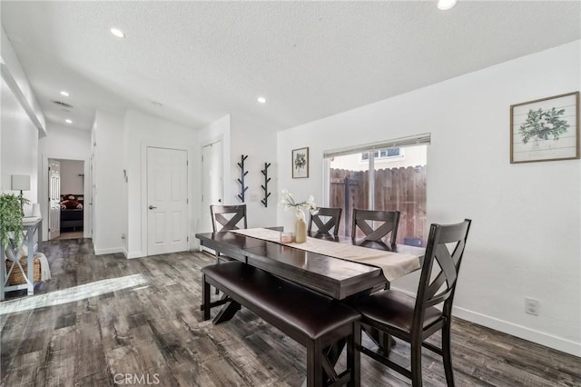 dining room featuring vaulted ceiling, a textured ceiling, wood finished floors, and baseboards