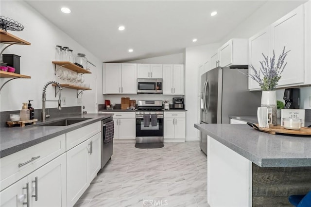 kitchen featuring lofted ceiling, stainless steel appliances, white cabinetry, open shelves, and a sink