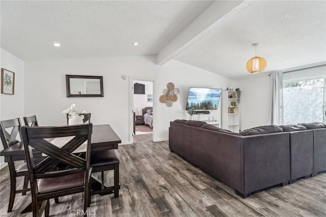 living area with lofted ceiling with beams, a textured ceiling, baseboards, and wood finished floors