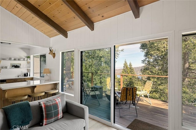 doorway to outside with lofted ceiling with beams, wooden ceiling, light wood-style flooring, and wooden walls