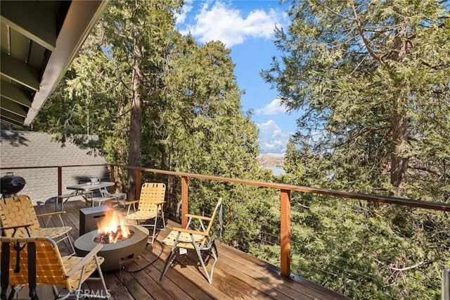 wooden terrace featuring an outdoor fire pit