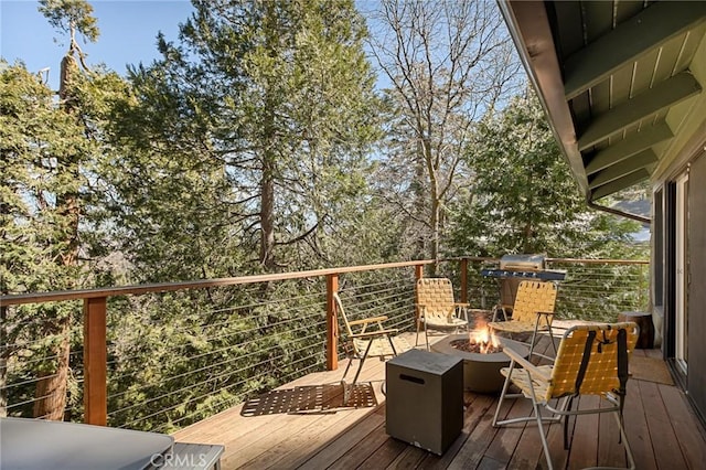 wooden deck with an outdoor fire pit and grilling area