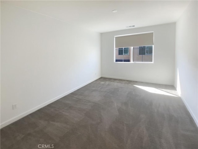 carpeted empty room with visible vents and baseboards