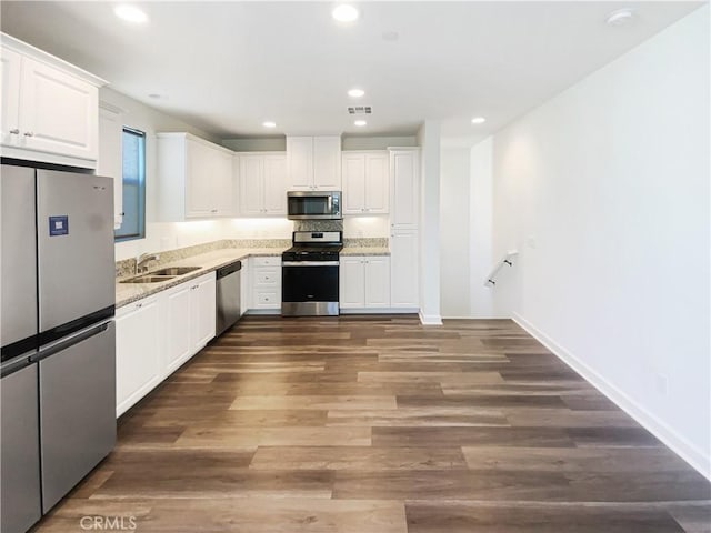 3622 E Delight Paseo Unit 112, Ontario, CA 91761 - kitchen with white cabinets, appliances with stainless steel finishes, a sink, wood finished floors, and visible vents