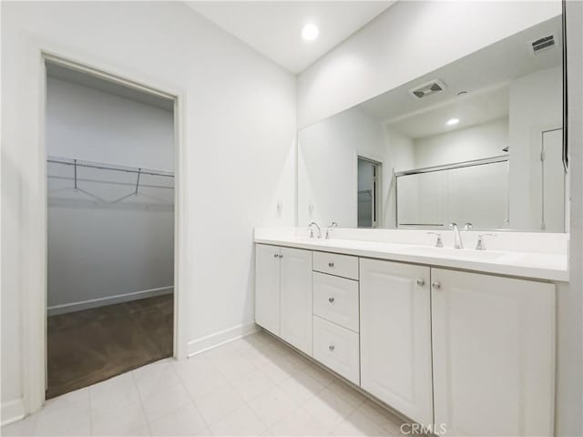 3622 E Delight Paseo Unit 112, Ontario, CA 91761 - bathroom featuring a walk in closet, a sink, double vanity, baseboards, and visible vents