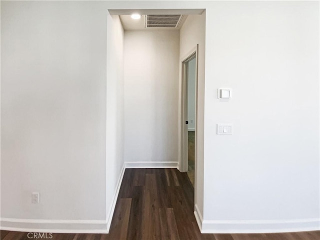 corridor featuring visible vents, dark wood finished floors, and baseboards