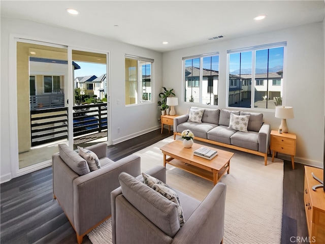 living area featuring recessed lighting, visible vents, baseboards, and wood finished floors