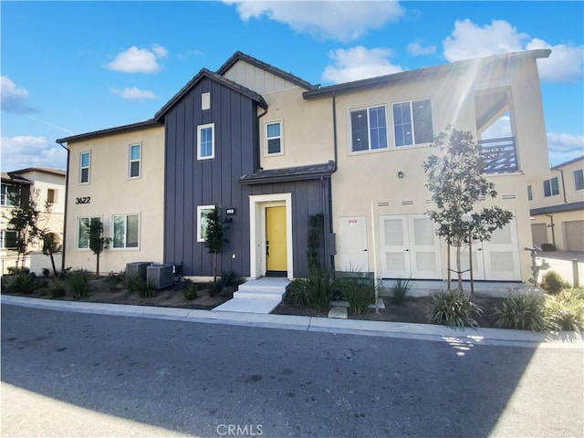 view of front of property with a garage, board and batten siding, and central air condition unit