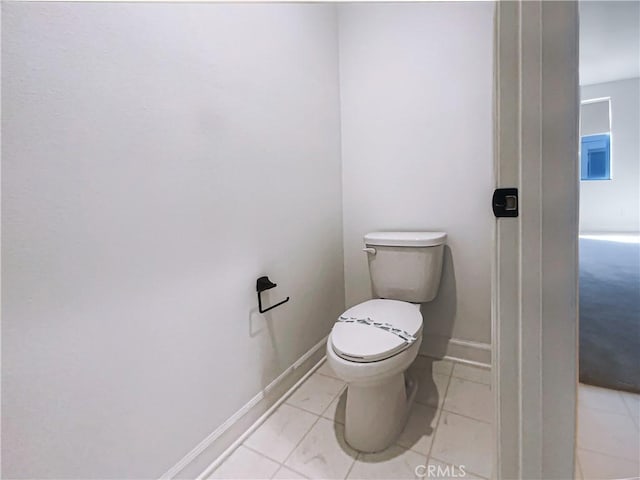 bathroom featuring baseboards, toilet, and tile patterned floors