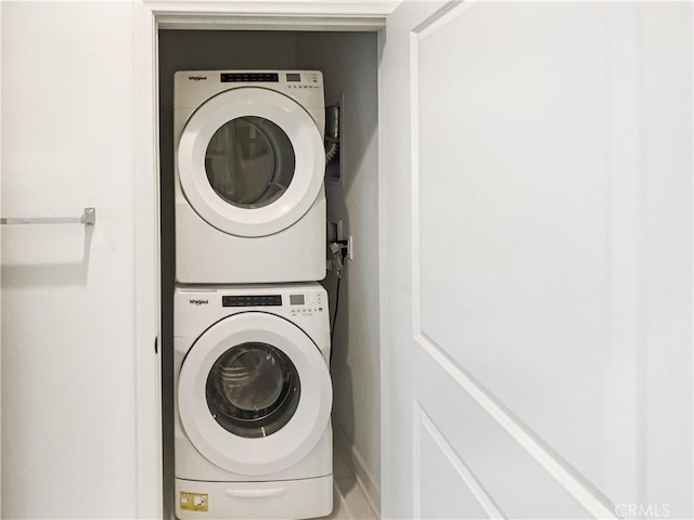 washroom with stacked washer and clothes dryer and laundry area