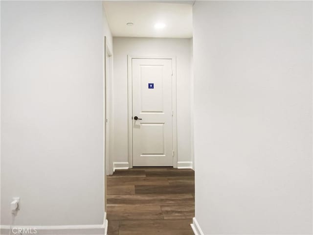 hallway with dark wood finished floors and baseboards