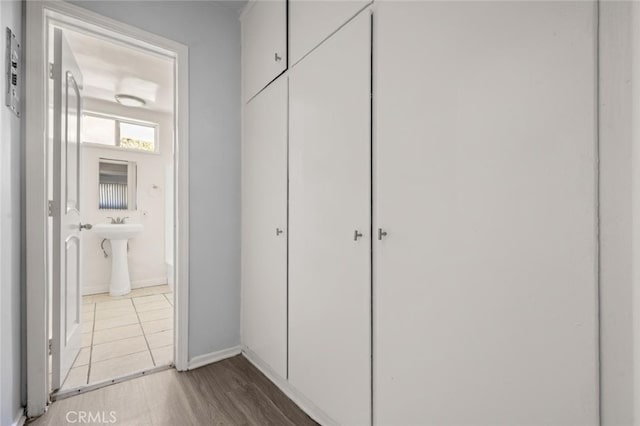 hallway featuring a sink and wood finished floors