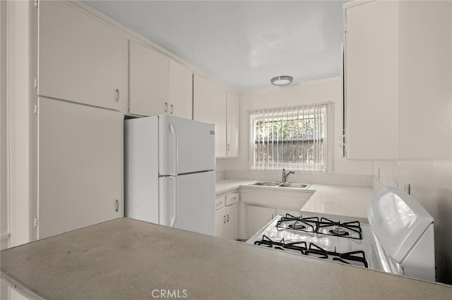 kitchen with light countertops, white appliances, a sink, and white cabinets