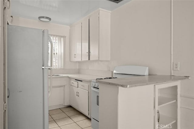 kitchen featuring white cabinets, white appliances, light tile patterned floors, and light countertops