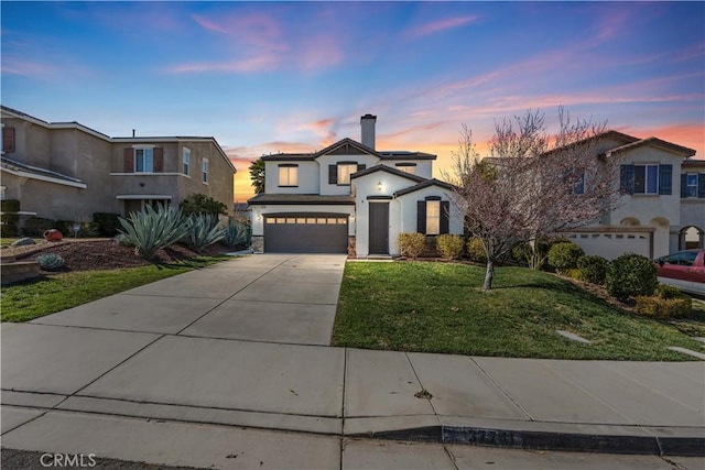 view of front of home with a garage, concrete driveway, a chimney, a front lawn, and stucco siding