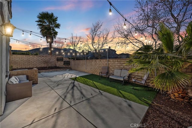 patio terrace at dusk with a fenced backyard