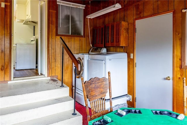 interior space featuring independent washer and dryer and wooden walls