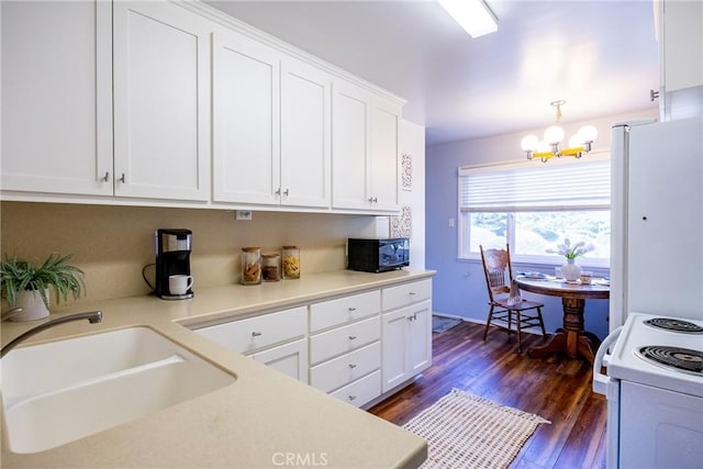 kitchen featuring dark wood finished floors, white appliances, white cabinets, and a sink