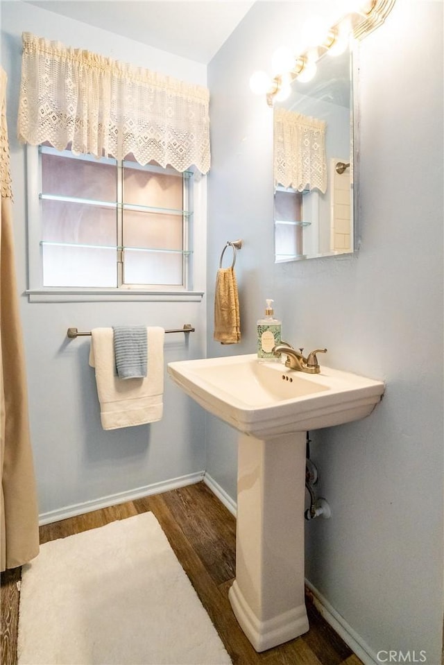 bathroom with baseboards and wood finished floors