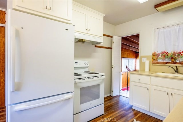 kitchen with white appliances, white cabinets, dark wood-style flooring, under cabinet range hood, and a sink