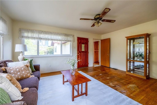 living area with visible vents, wood finished floors, and a ceiling fan