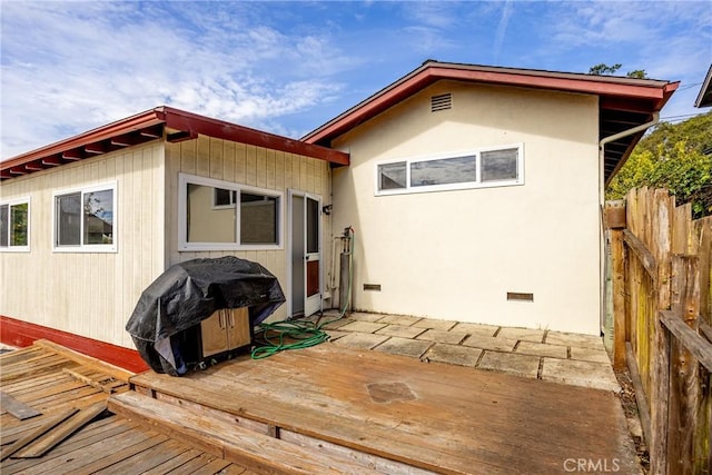 rear view of property with crawl space, fence, and a wooden deck