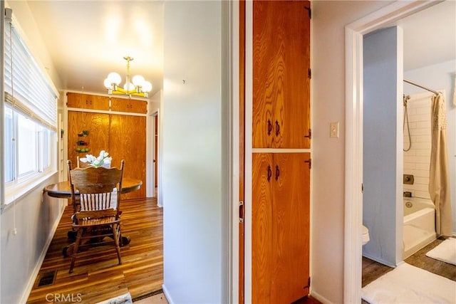 dining area featuring baseboards, visible vents, an inviting chandelier, and wood finished floors